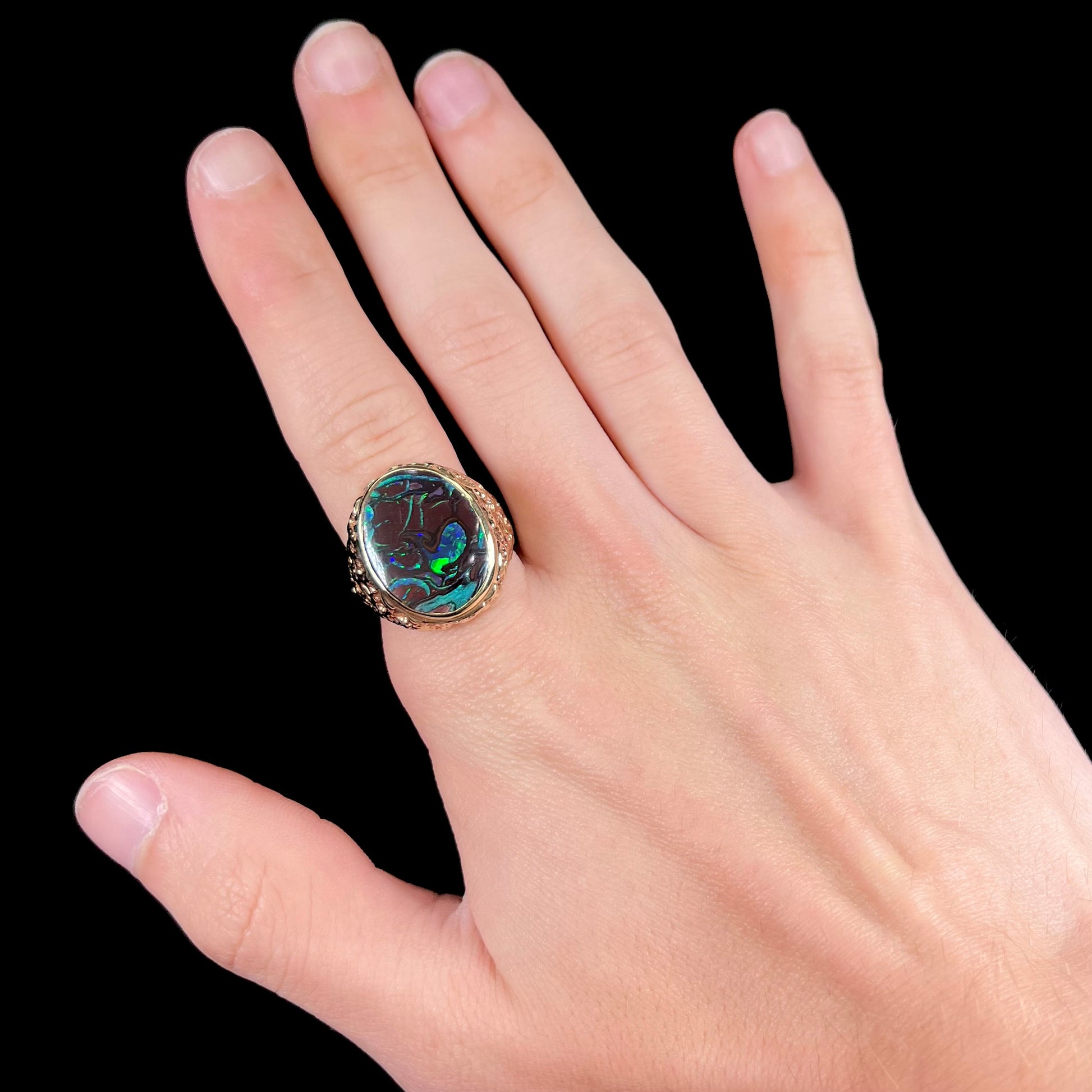 A men's yellow gold nugget style Koroit boulder opal solitaire ring.