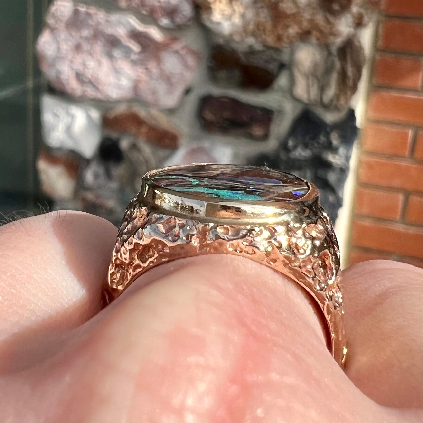 A men's yellow gold nugget style Koroit boulder opal solitaire ring.