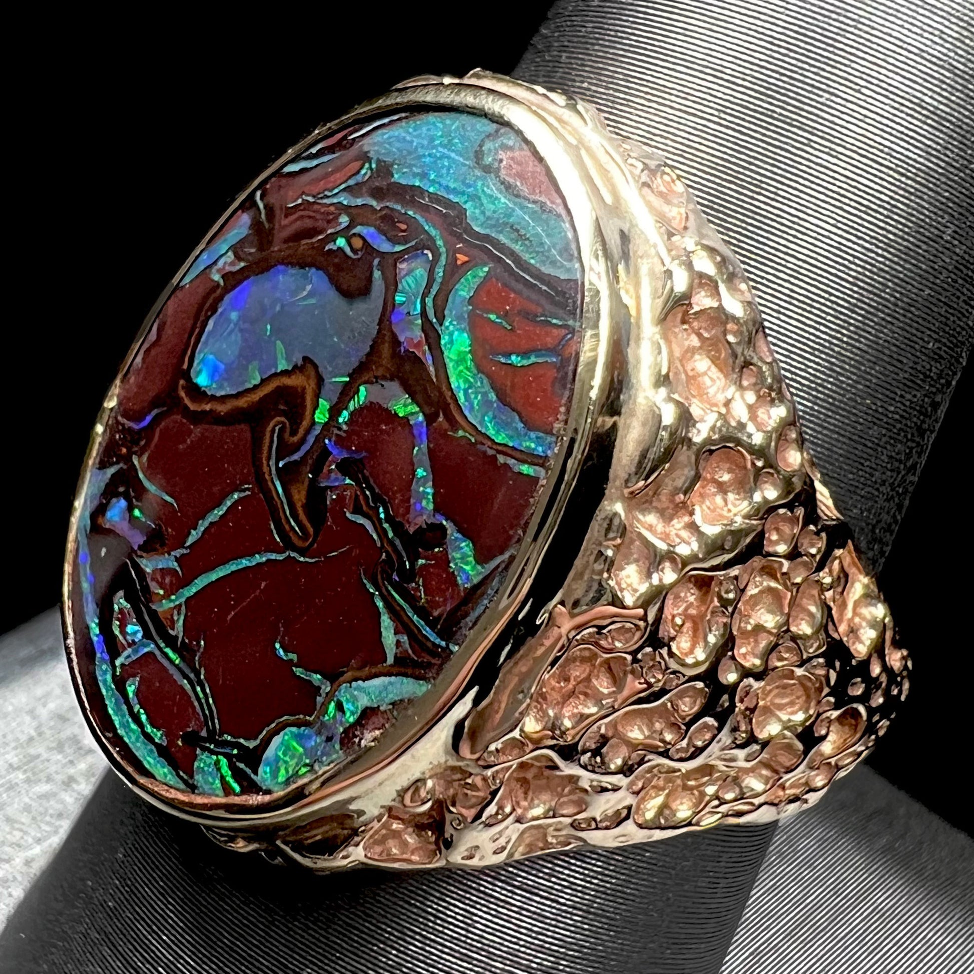 A men's yellow gold nugget style Koroit boulder opal solitaire ring.