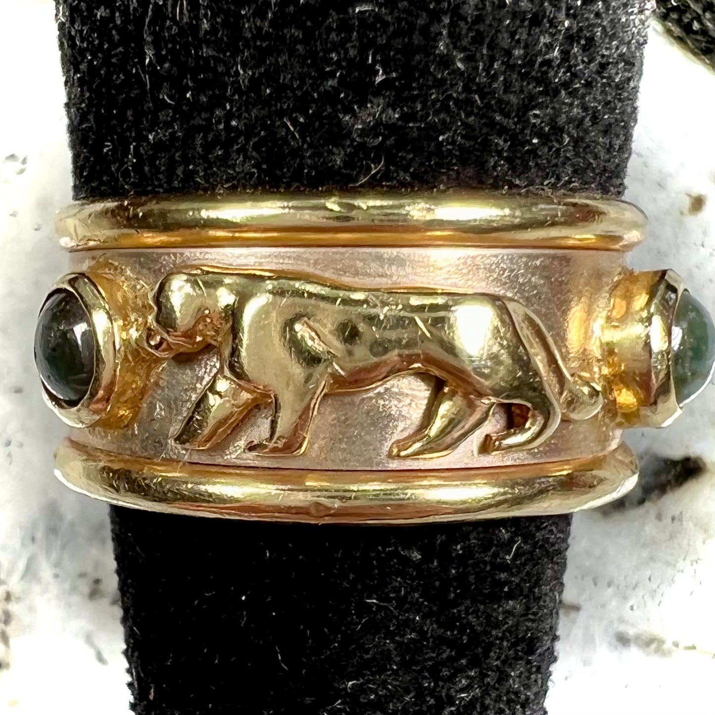 Men's gold ring set with three cabochon cut cat's eye alexandrite stones and panther designs.