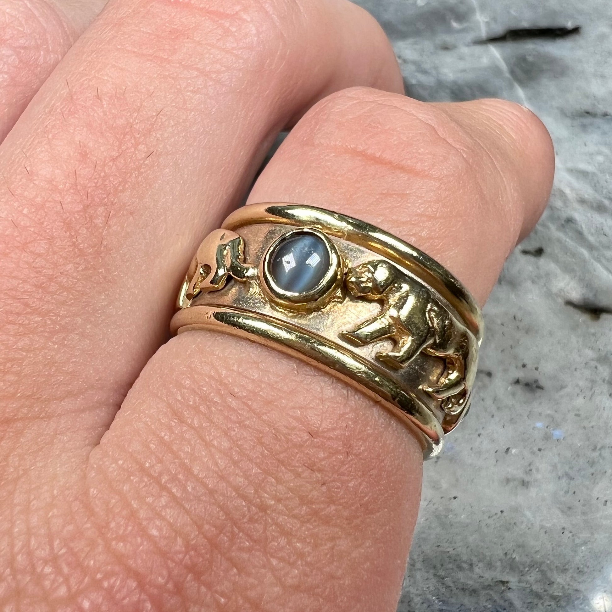 Men's gold ring set with three cabochon cut cat's eye alexandrite stones and panther designs.