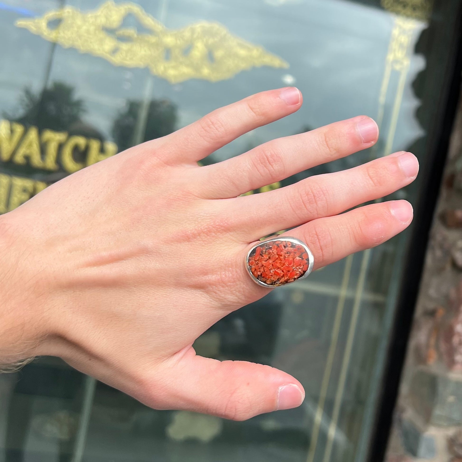A rustic style, handmade silver men's ring set with crushed red coral.