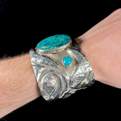 A men's sterling silver cuff bracelet set with two oval cut chrysocolla stones.