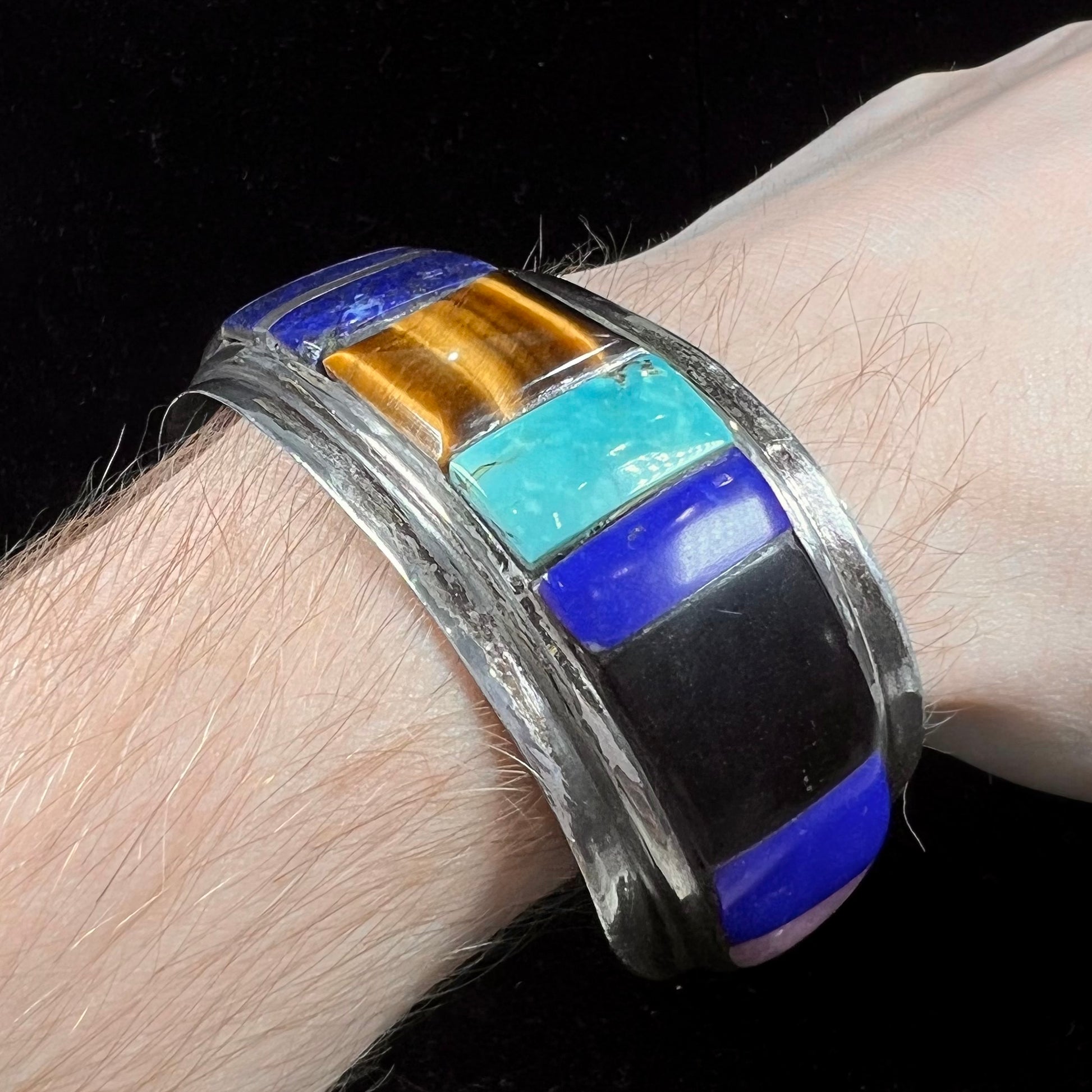 A men's vintage sterling silver Hopi Indian cuff bracelet set with tiger's eye, lapis lazuli, turquoise, jet, and rhodonite.