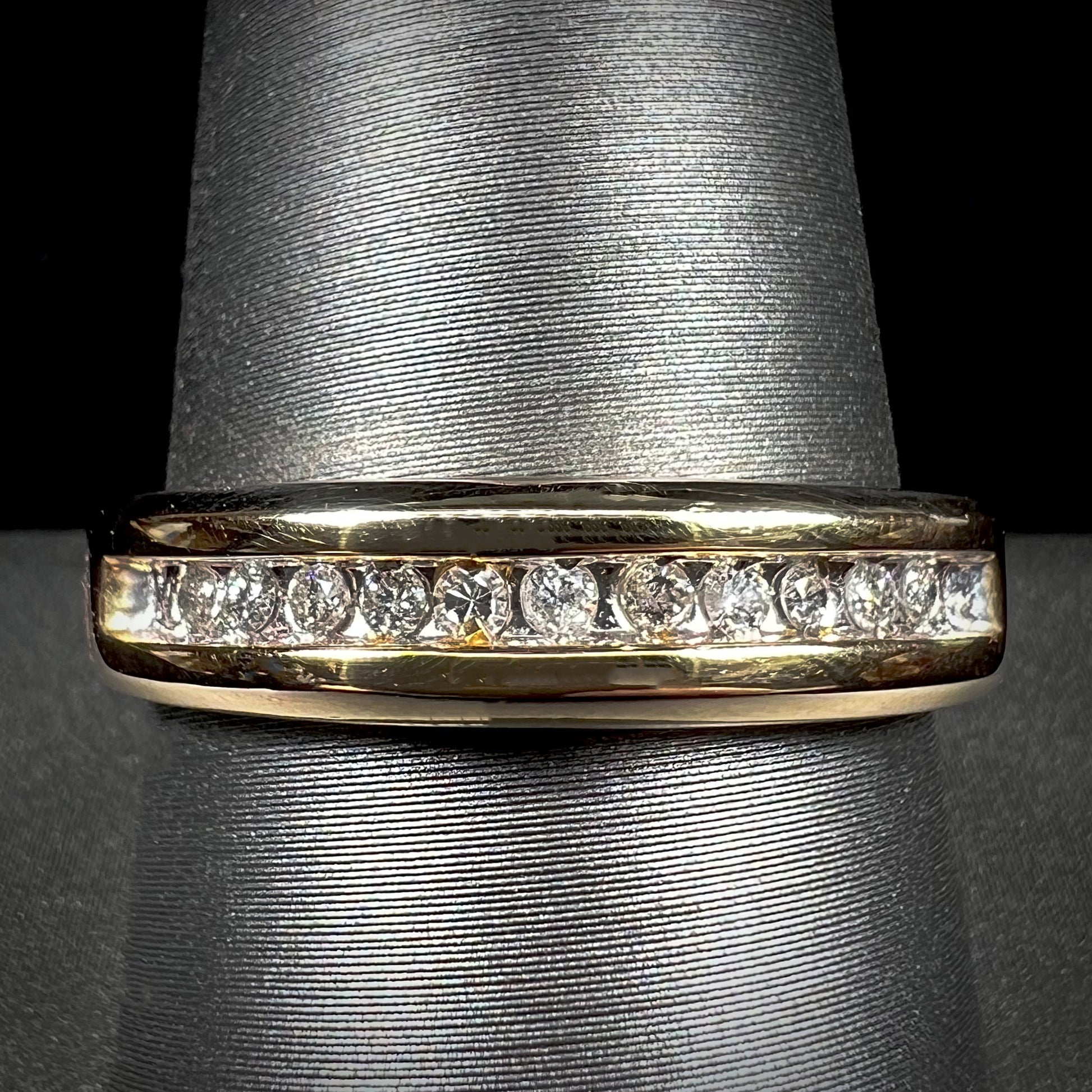 A men's yellow gold channel set diamond wedding band.