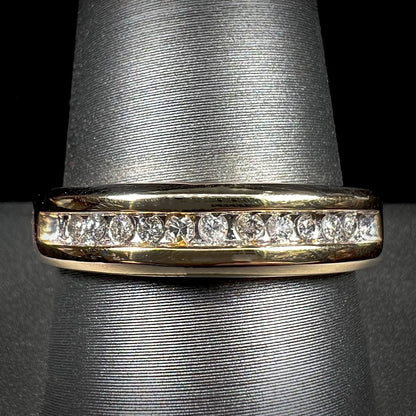 A men's yellow gold channel set diamond wedding band.