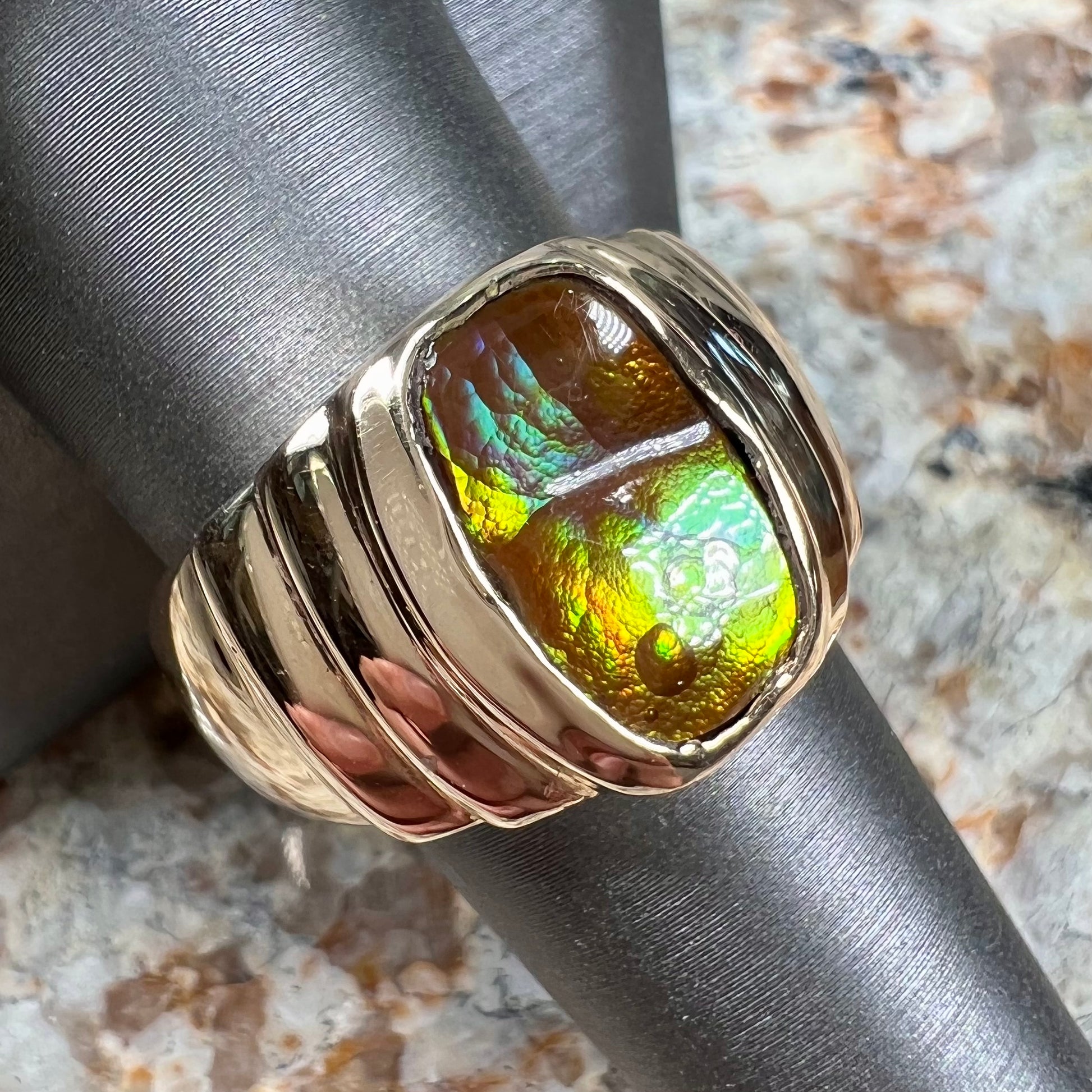 Men's fire agate solitaire ring cast in yellow gold.  The ring is a step design.