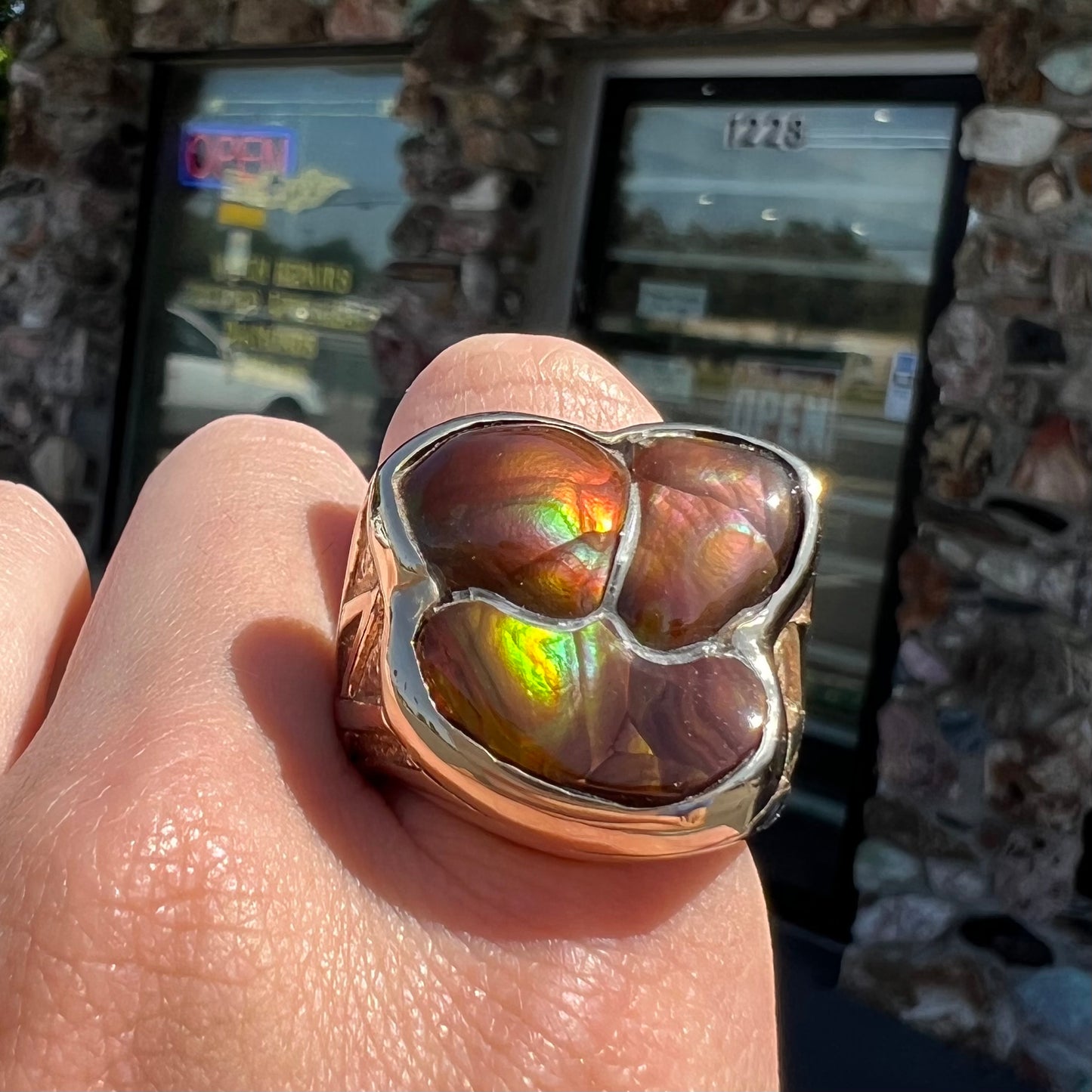A men's yellow gold ring inlaid with three freeform cut fire agate stones.