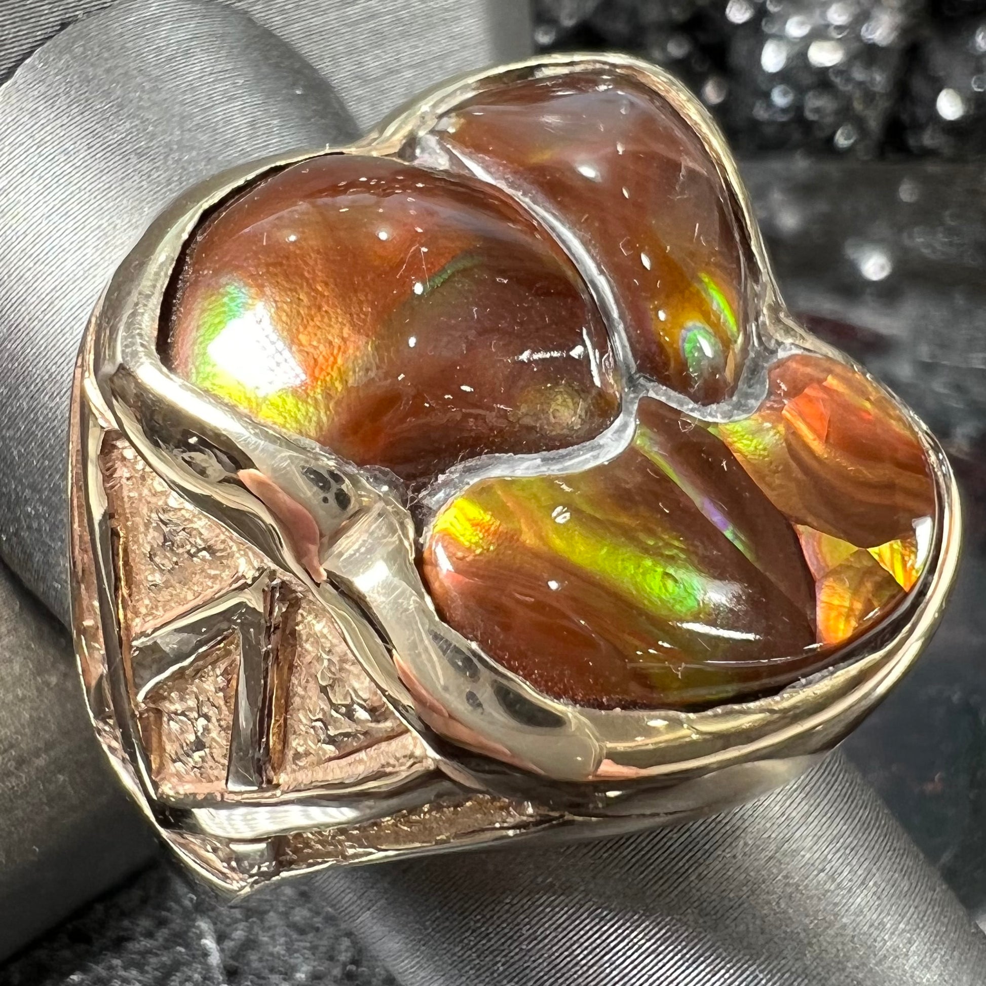 A men's yellow gold ring inlaid with three freeform cut fire agate stones.