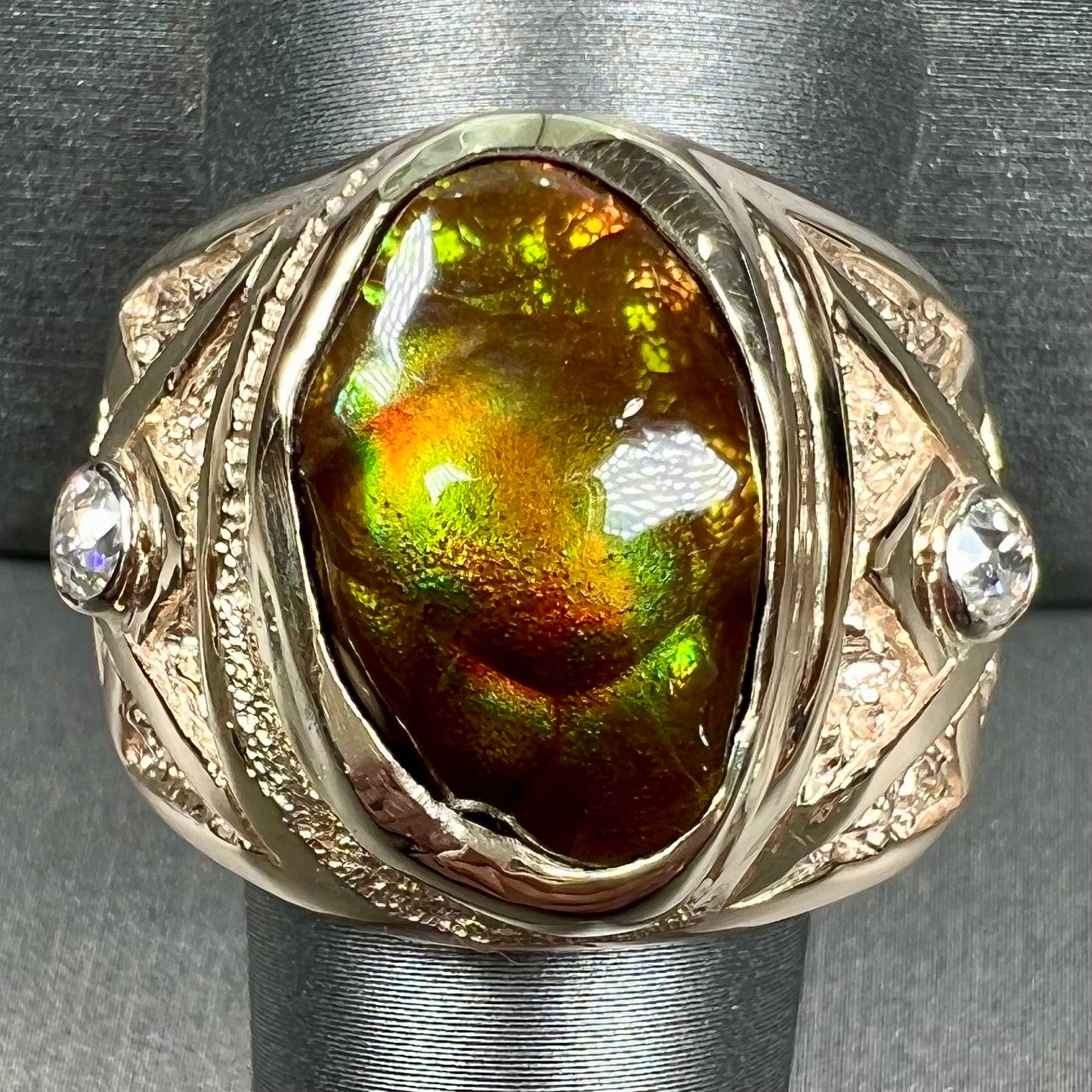 A men's solid yellow gold fire agate and diamond ring.  The fire agate displays predominantly red and green.