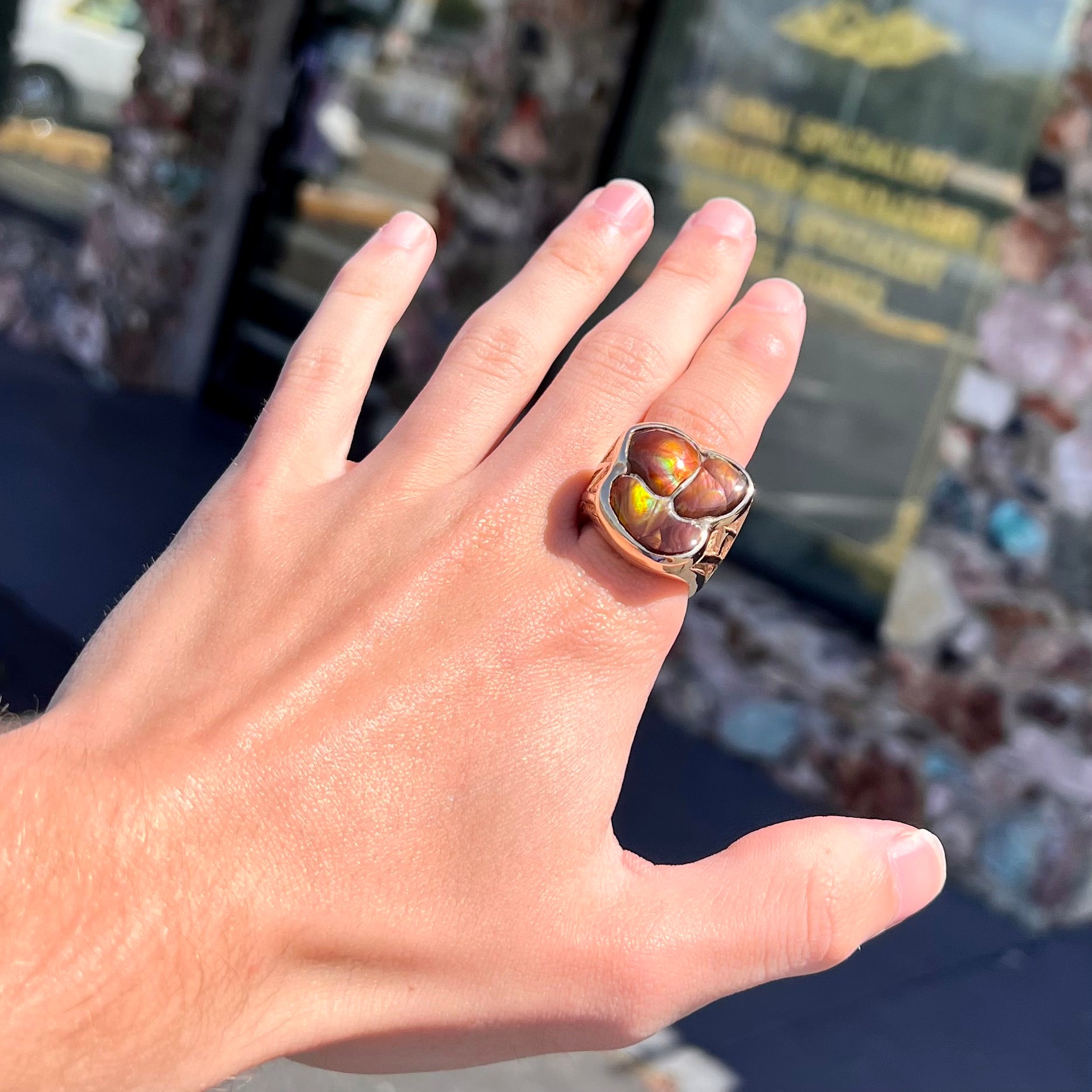 A men's yellow gold ring inlaid with three freeform cut fire agate stones.