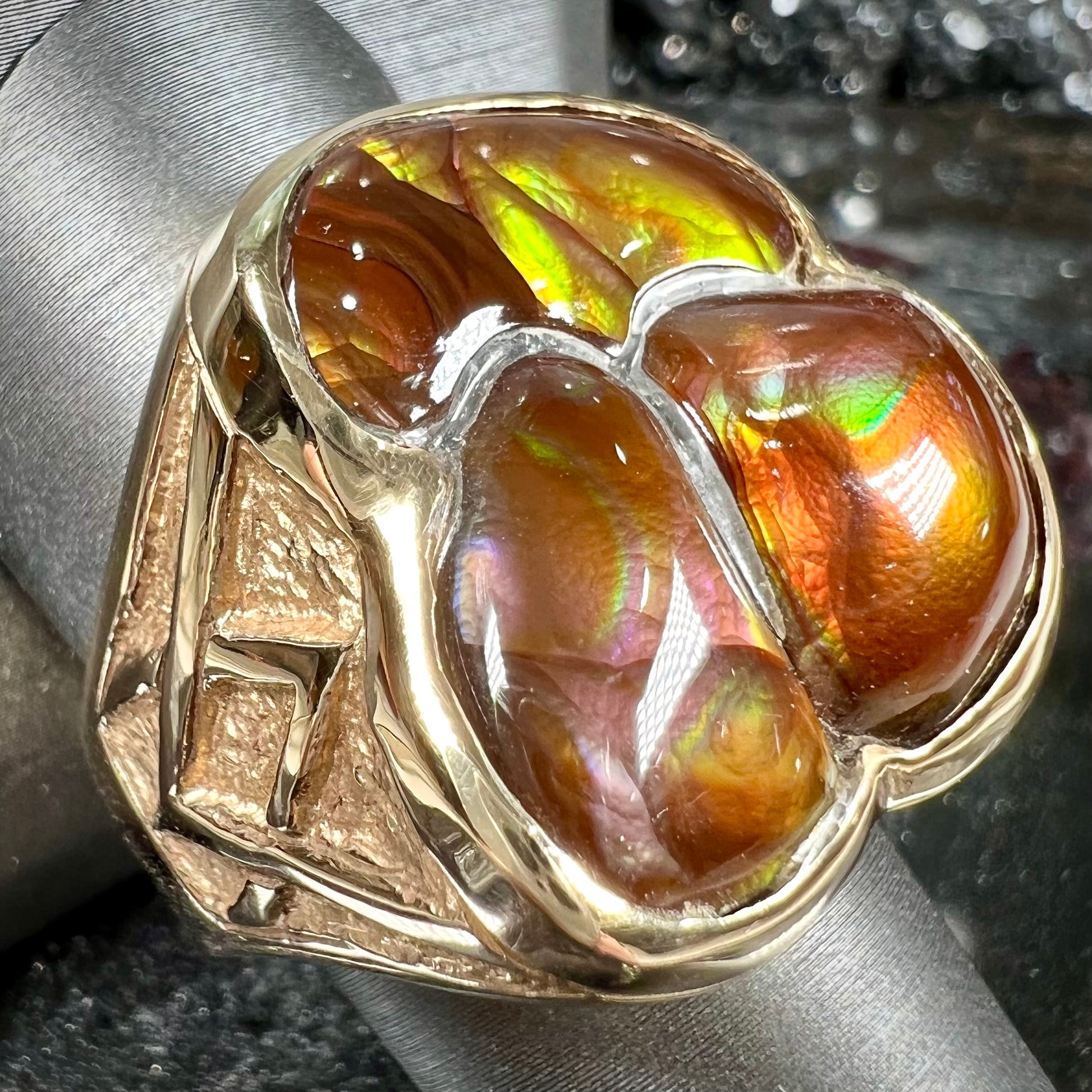 A men's yellow gold ring inlaid with three freeform cut fire agate stones.
