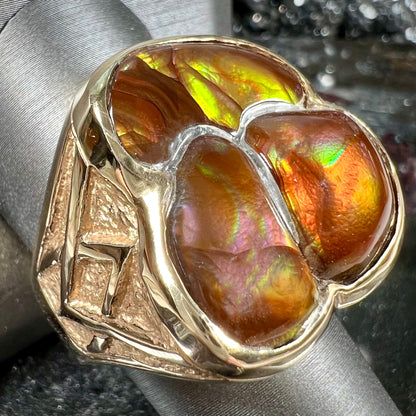 A men's yellow gold ring inlaid with three freeform cut fire agate stones.