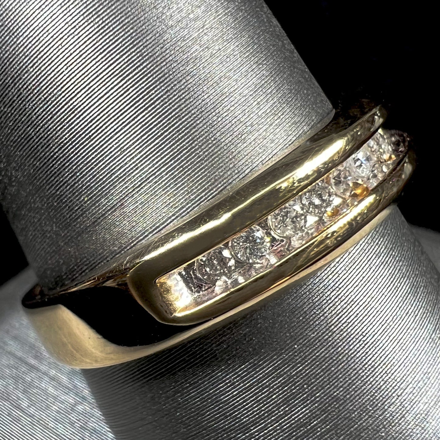 A men's yellow gold channel set diamond wedding band.