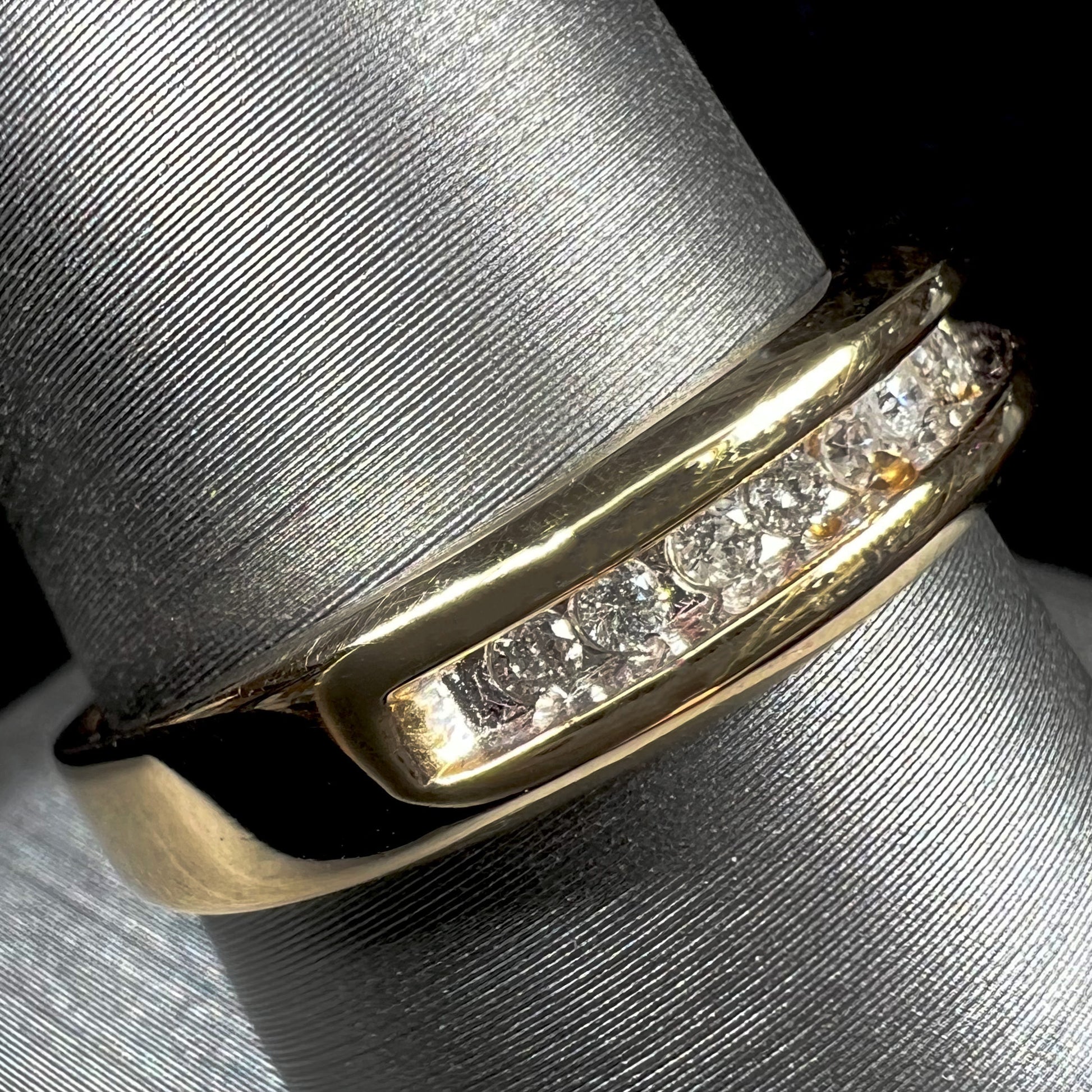 A men's yellow gold channel set diamond wedding band.