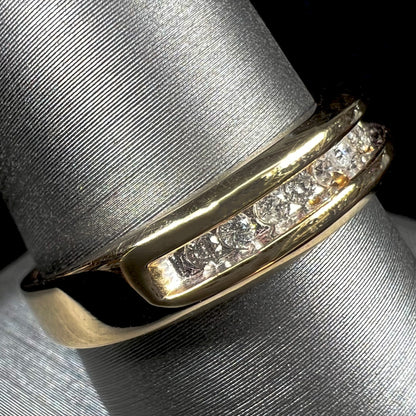 A men's yellow gold channel set diamond wedding band.
