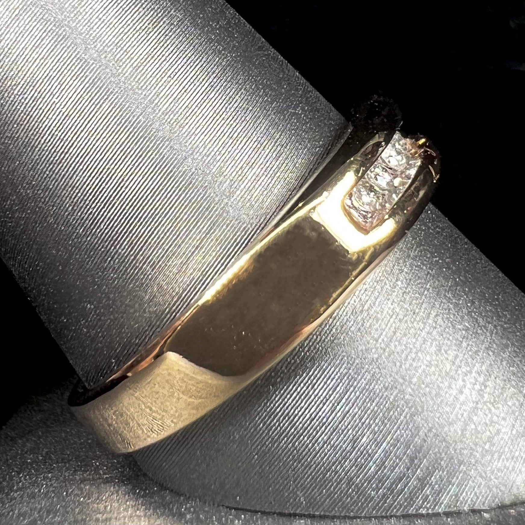 A men's yellow gold channel set diamond wedding band.