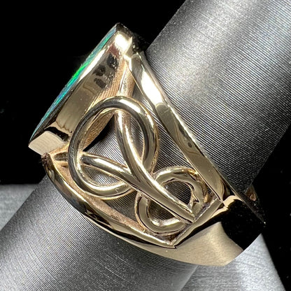 A men's natural Lightning Ridge, Australian black opal solitaire ring cast in yellow gold.