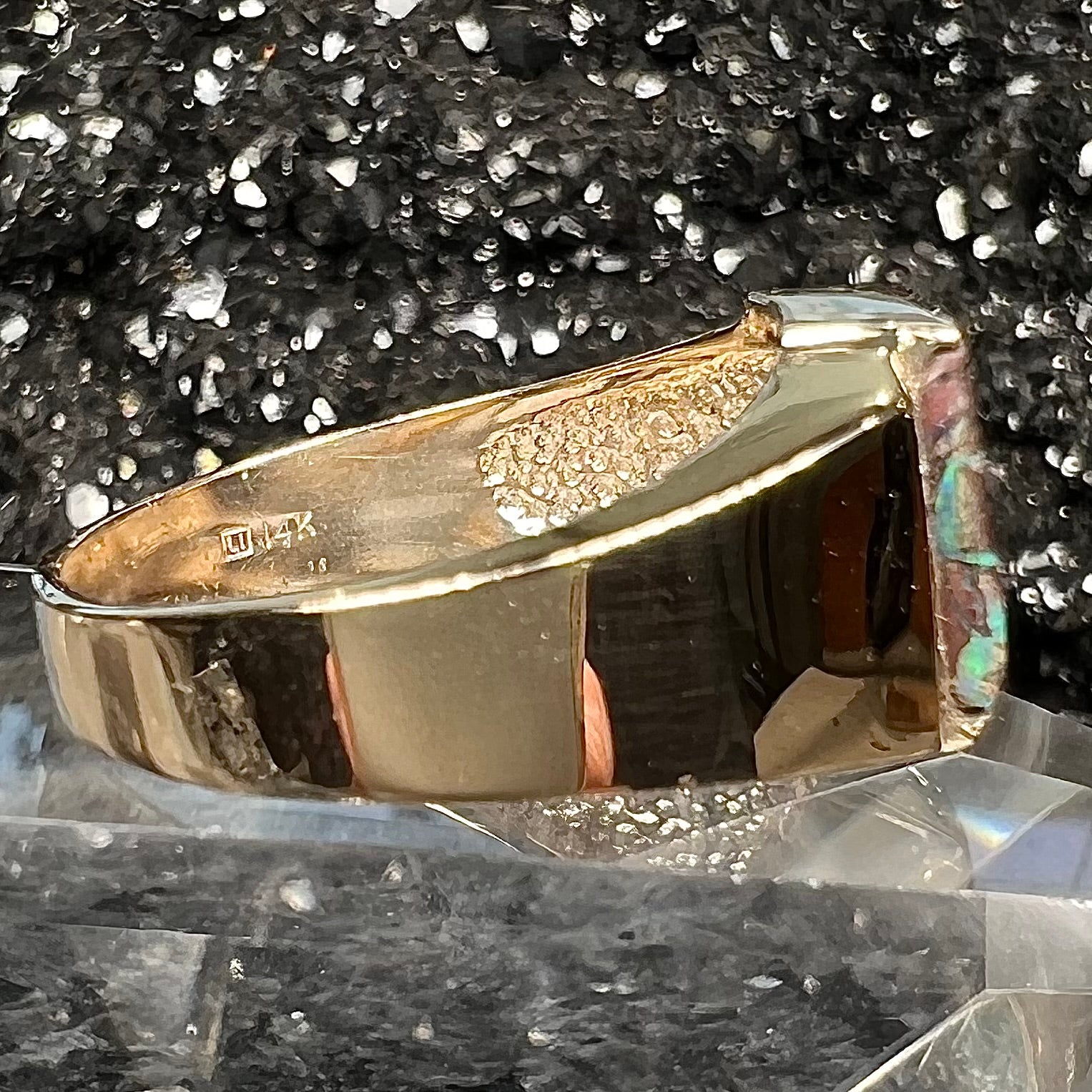 A men's gold boulder opal and diamond ring.  The opal shows blue and green colors.