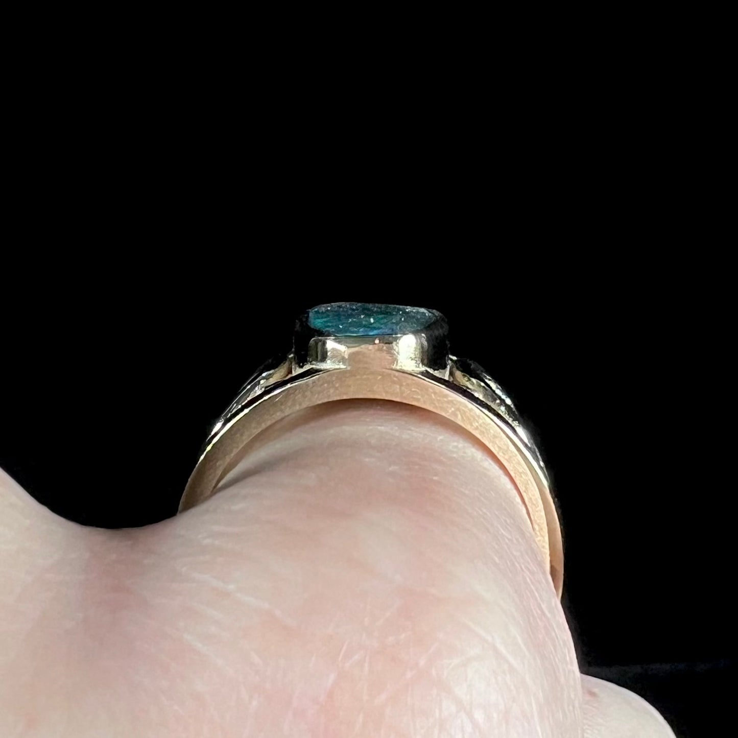 A men's natural Lightning Ridge, Australian black opal solitaire ring cast in yellow gold.