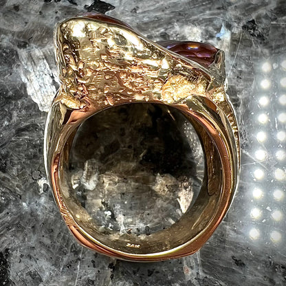 A men's Deer Creek fire agate solitaire ring cast in yellow gold.  The stone is predominantly purple.