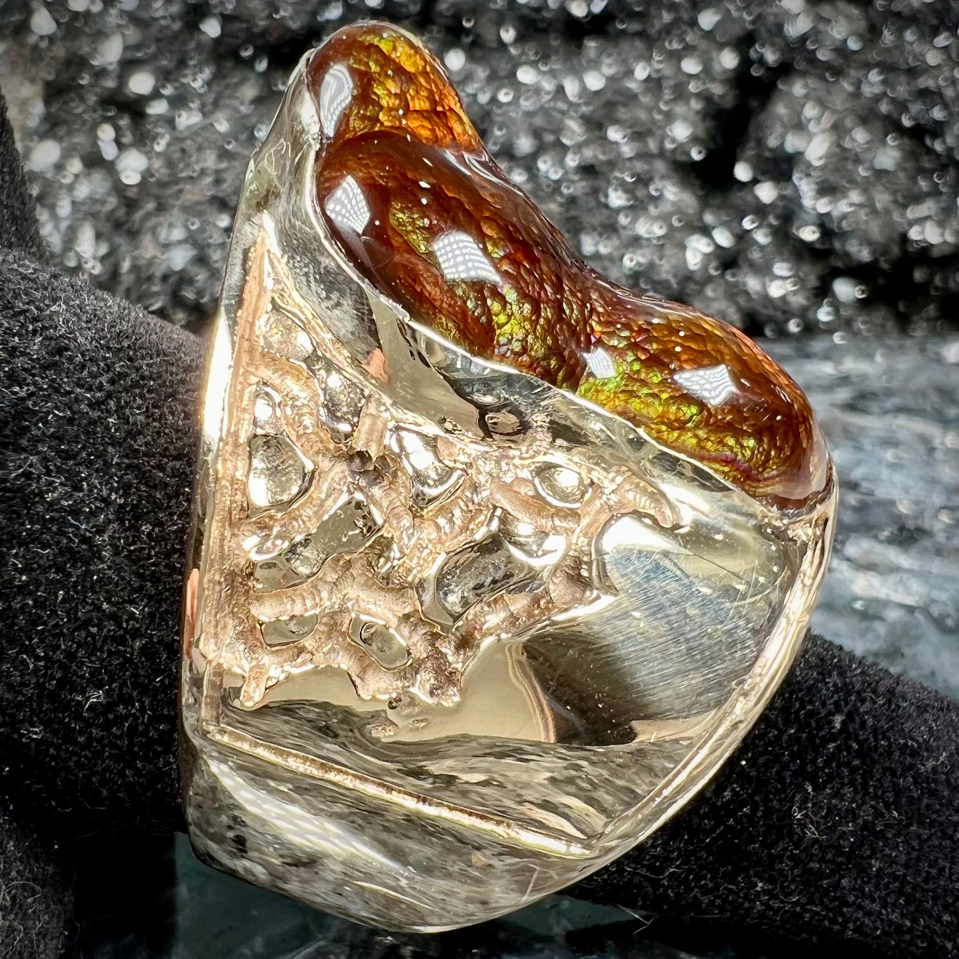 A large nugget style men's fire agate ring cast in yellow gold.  The fire agate is predominantly orange and green.