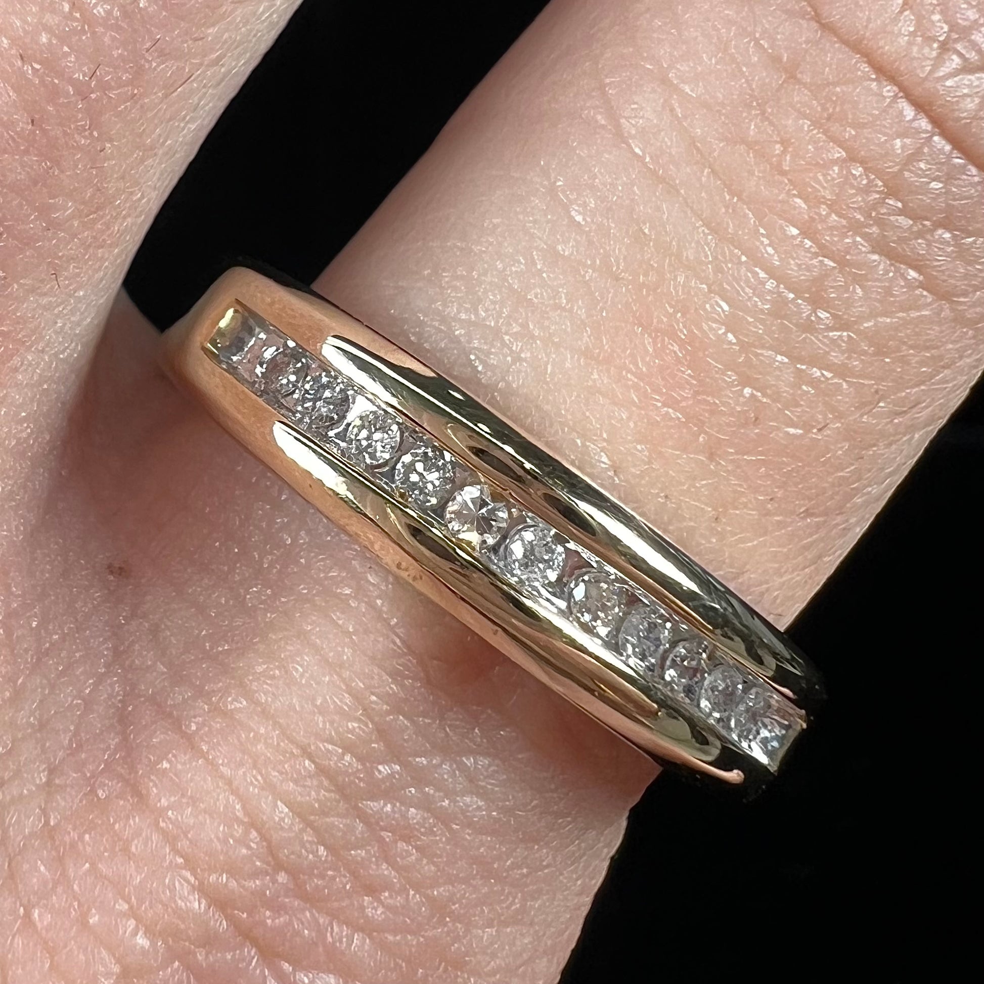 A men's yellow gold channel set diamond wedding band.