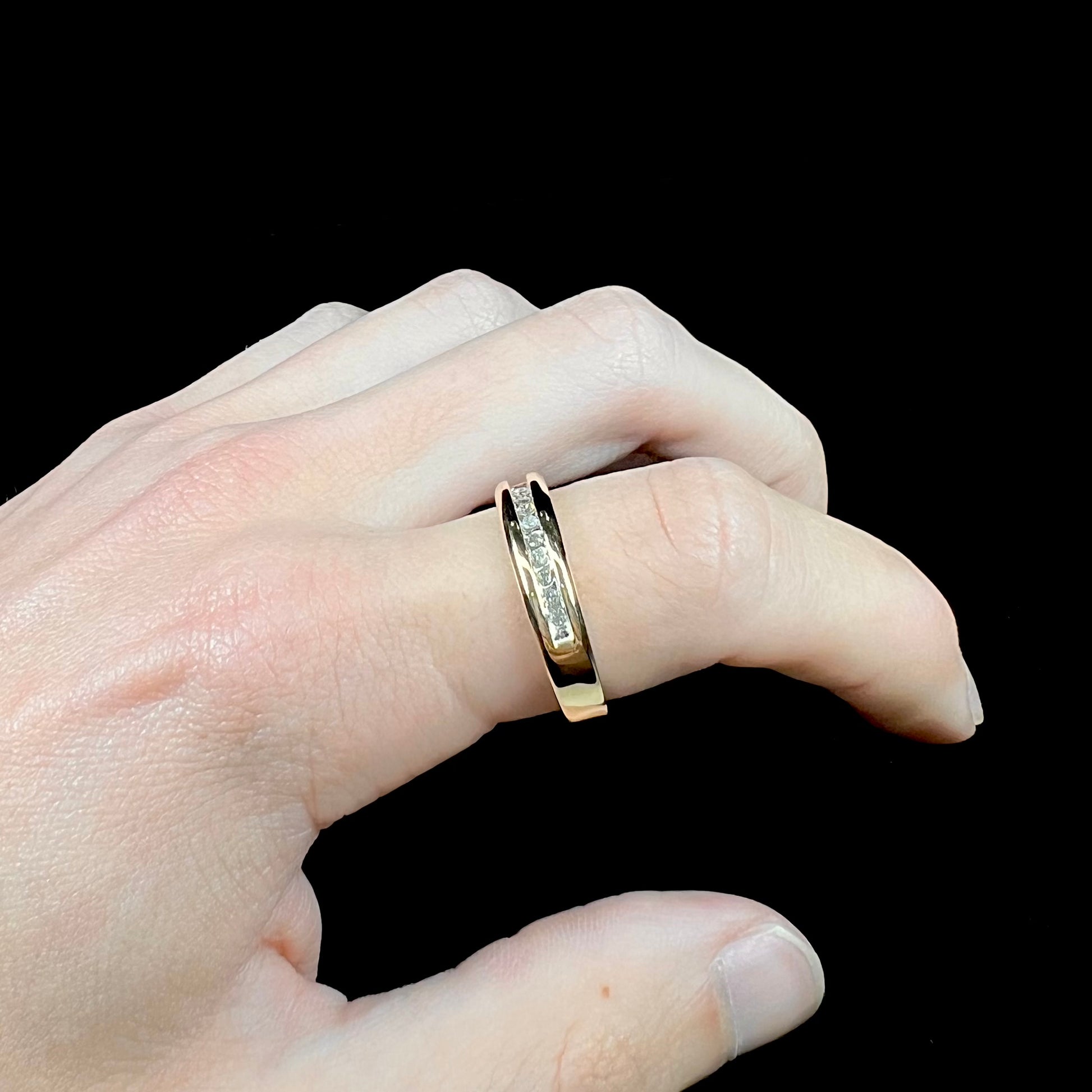 A men's yellow gold channel set diamond wedding band.