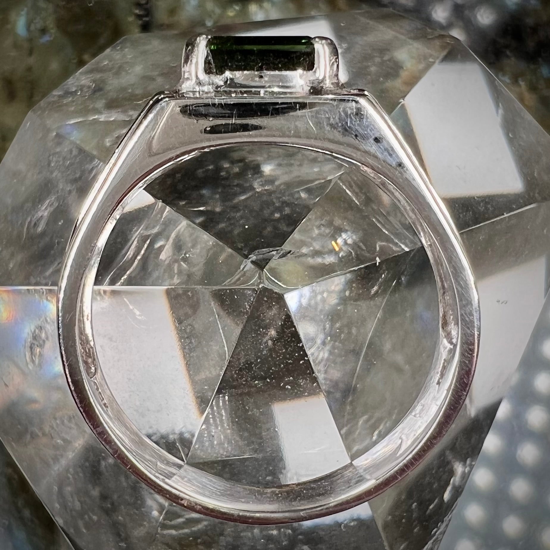 An 18k white gold green tourmaline and diamond men's ring.  The stones are princess cut.