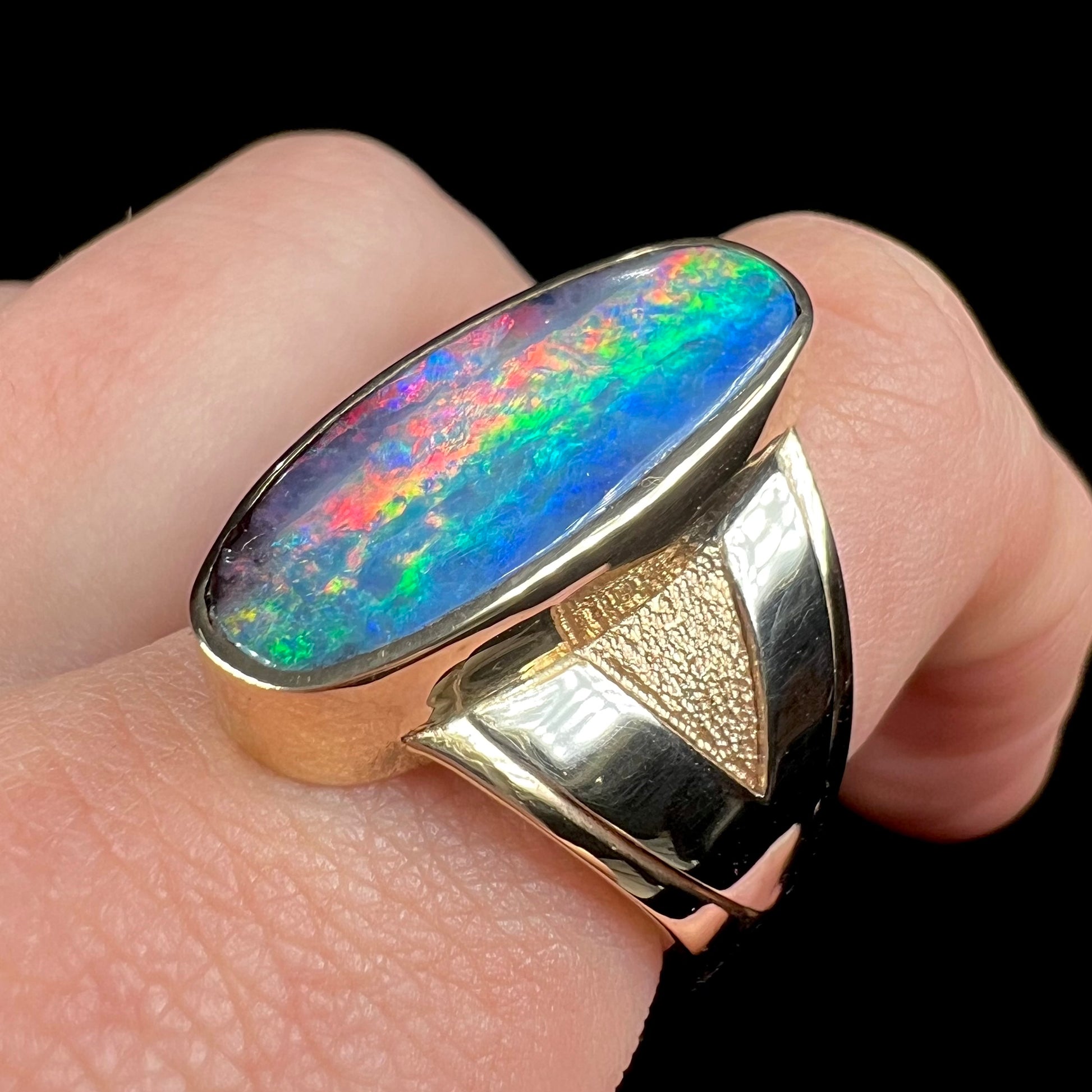 A men's two-tone gold solitaire ring set with a natural boulder opal from Koroit Mining District, Australia.