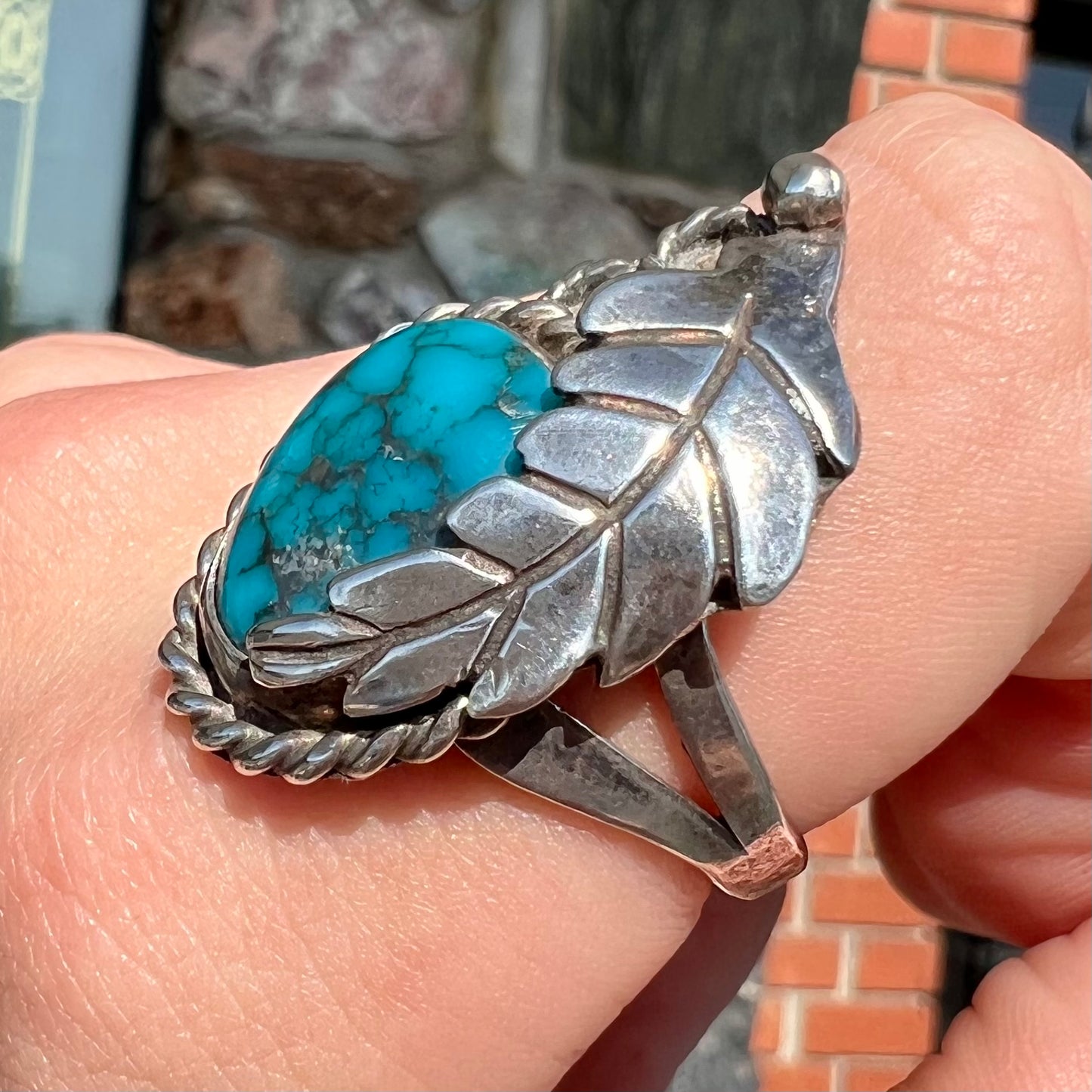 A handmade Navajo men's turquoise ring.  The ring is made with wire and carved silver.