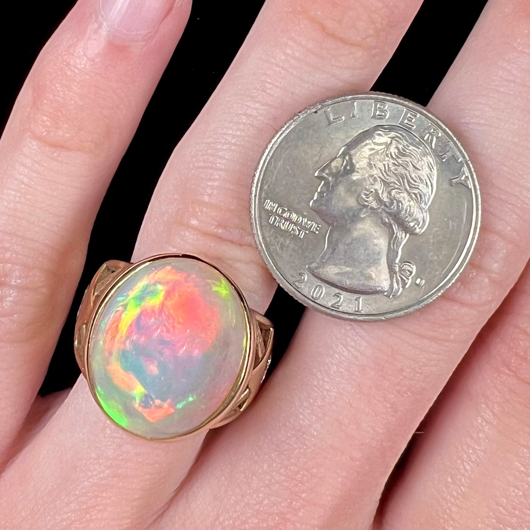 A custom yellow gold men's ring set with two diamonds and a large oval cabochon cut opal from Ethiopia, Africa.