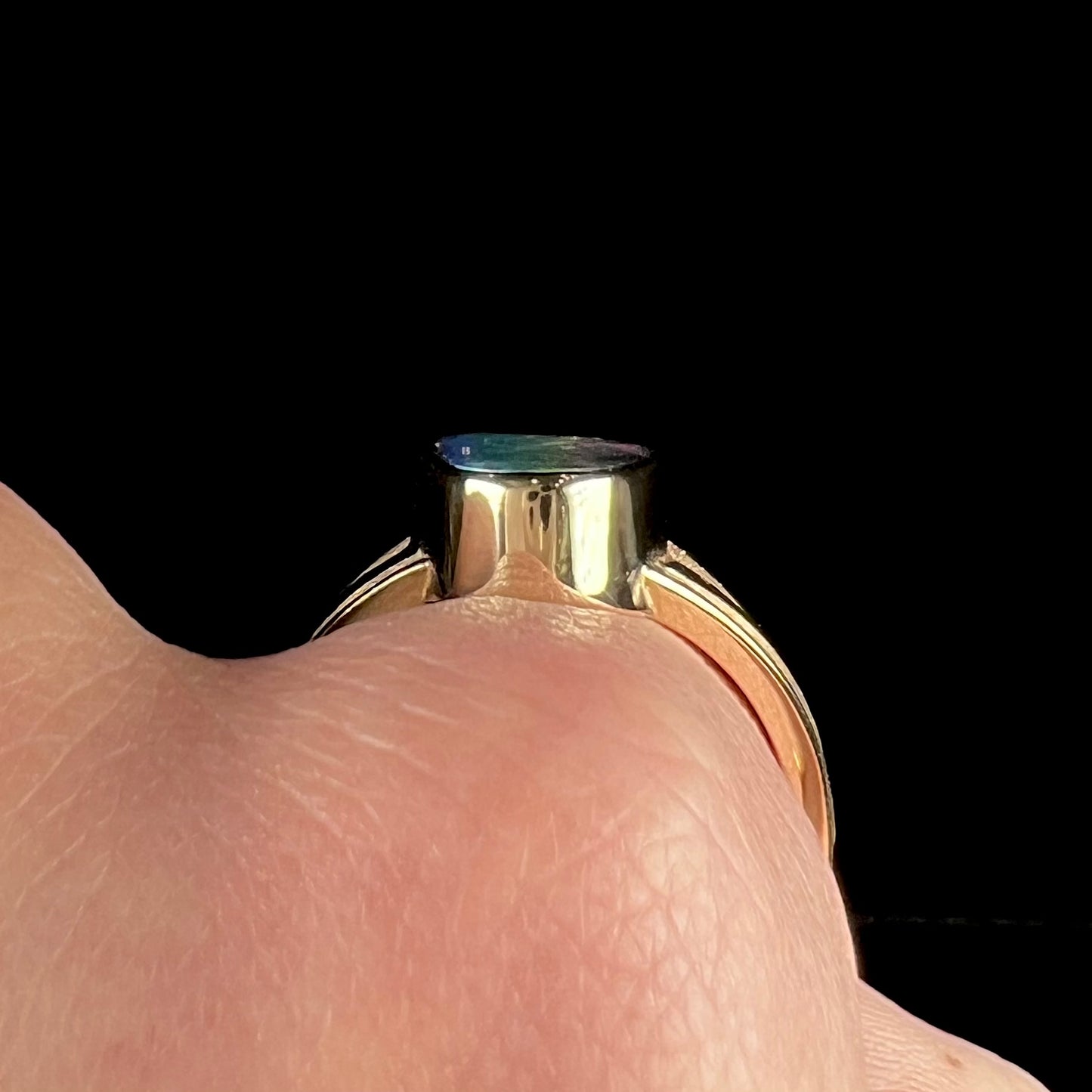 A men's two-tone gold solitaire ring set with a natural boulder opal from Koroit Mining District, Australia.