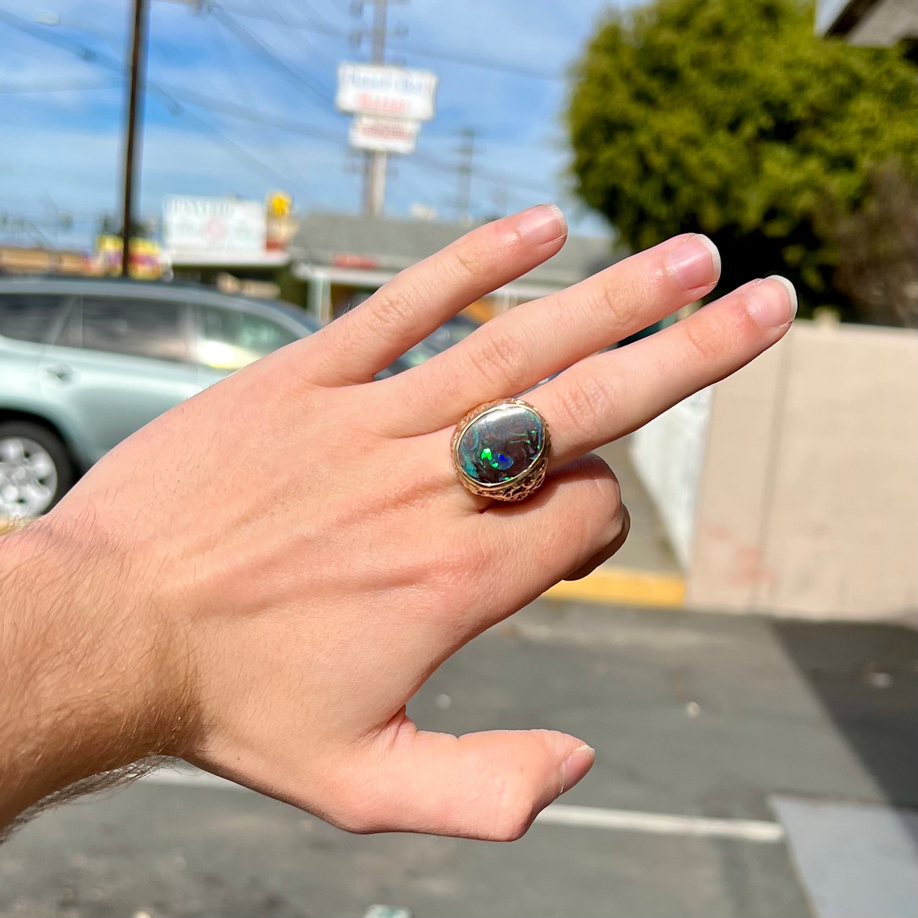 A men's yellow gold nugget style Koroit boulder opal solitaire ring.