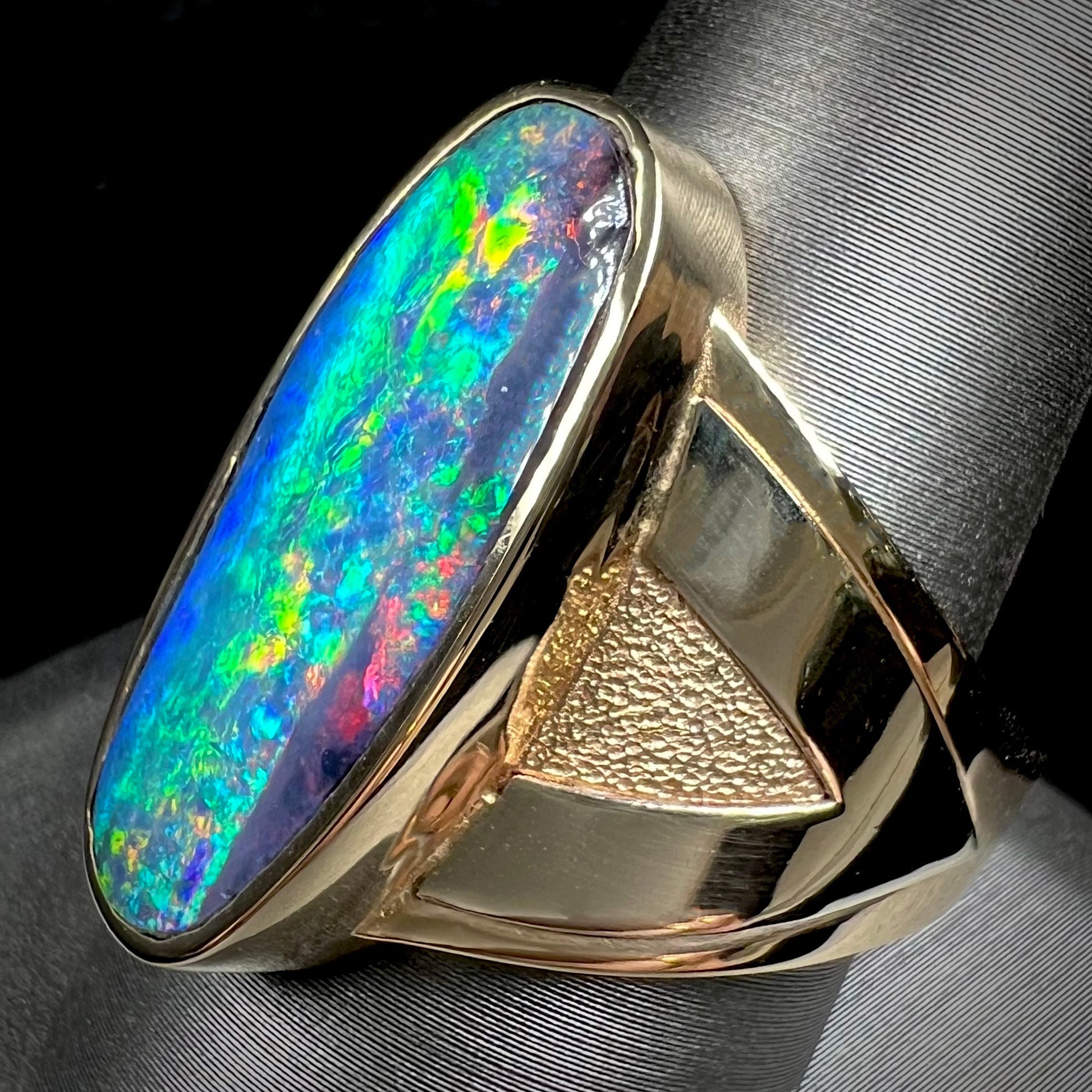 A men's two-tone gold solitaire ring set with a natural boulder opal from Koroit Mining District, Australia.