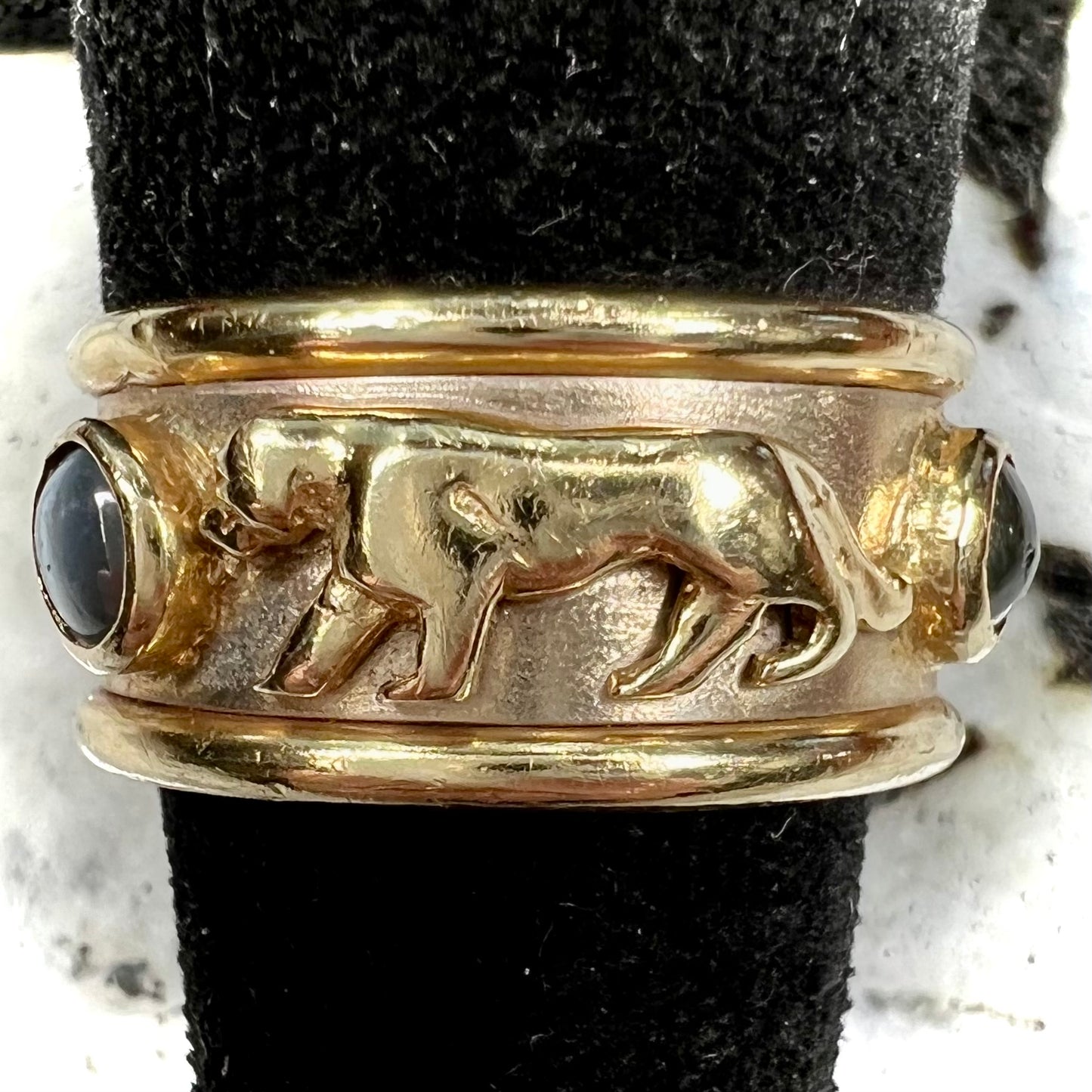 Men's gold ring set with three cabochon cut cat's eye alexandrite stones and panther designs.