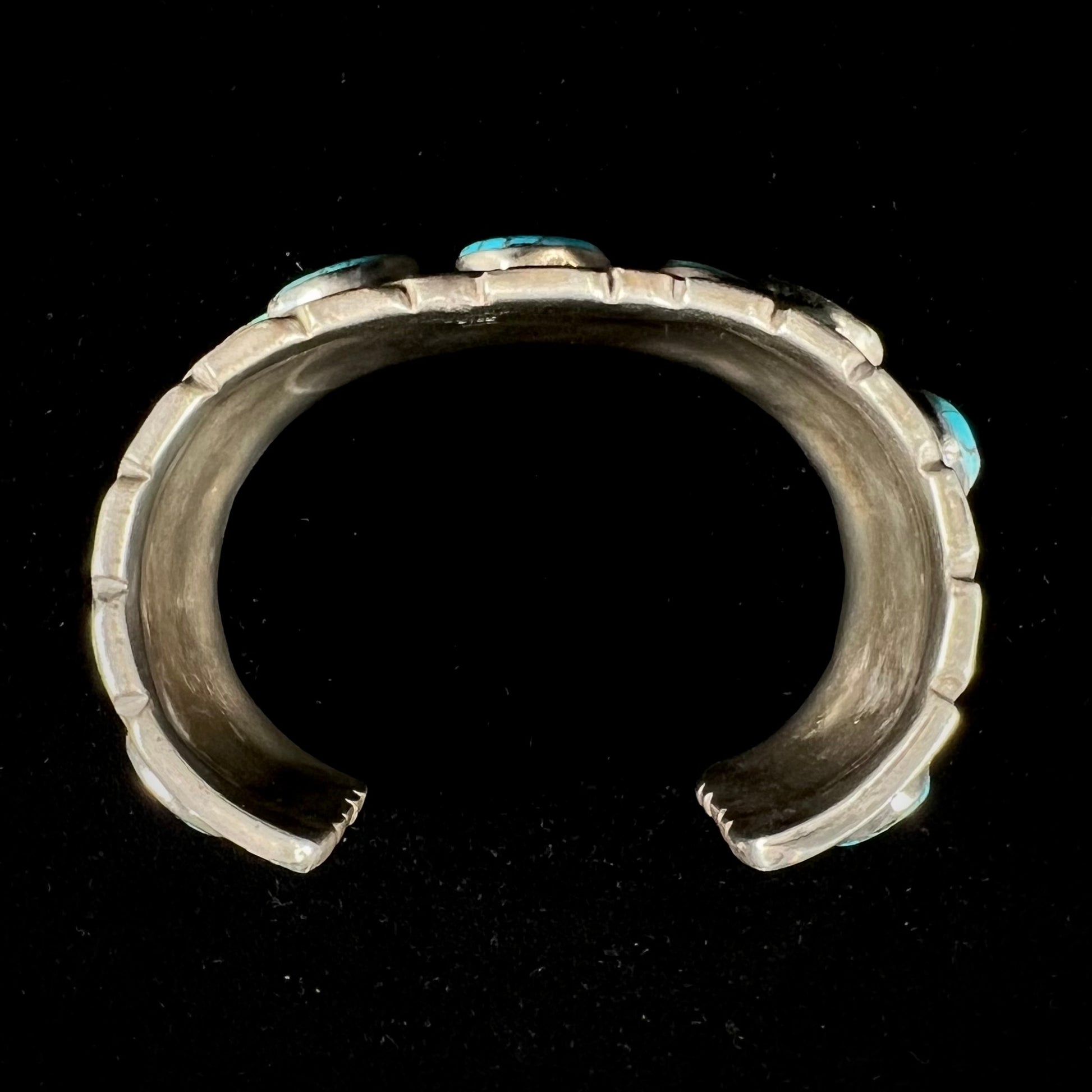 A men's sterling silver cuff bracelet bezel set with natural and synthetic turquoise stones.