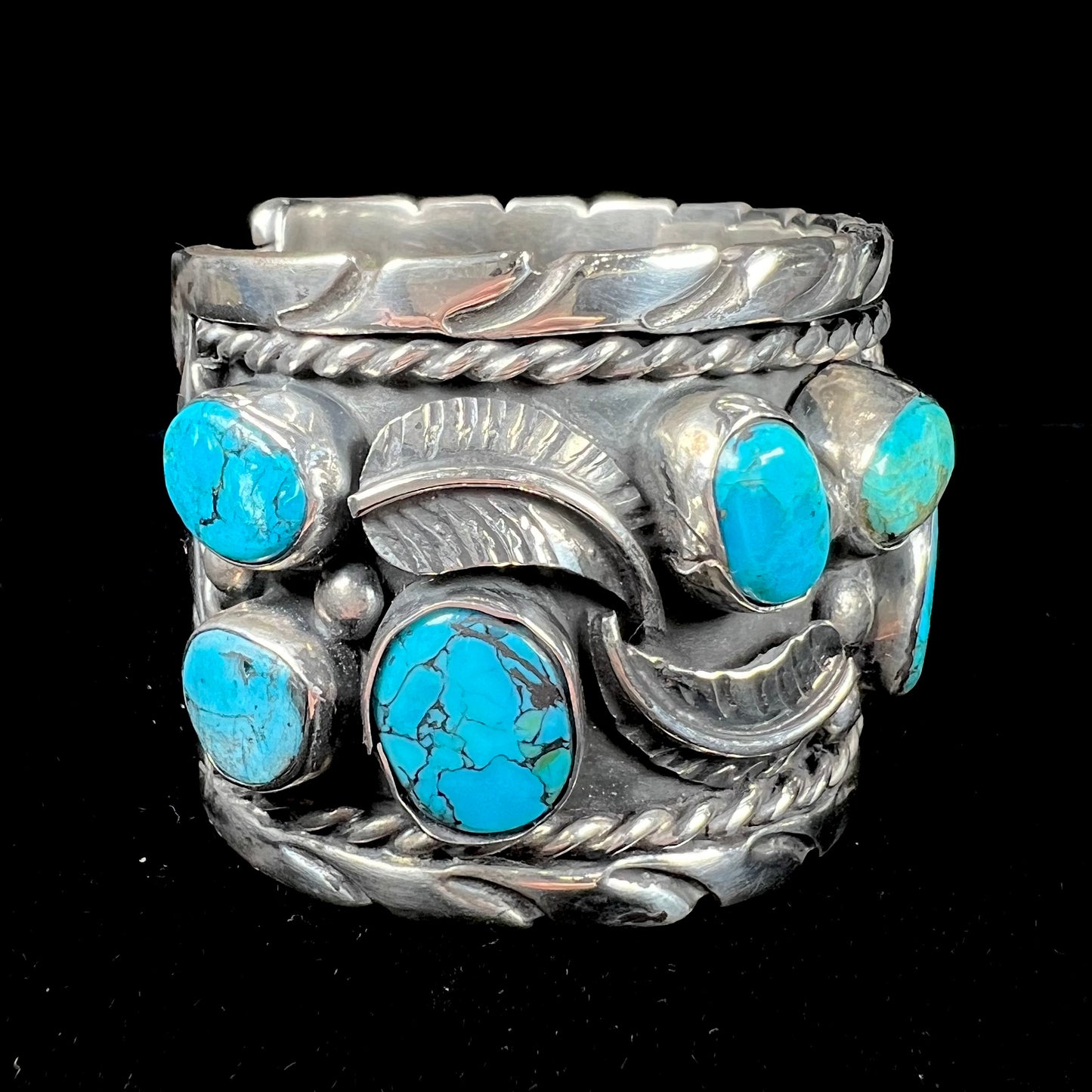 A men's sterling silver cuff bracelet bezel set with natural and synthetic turquoise stones.