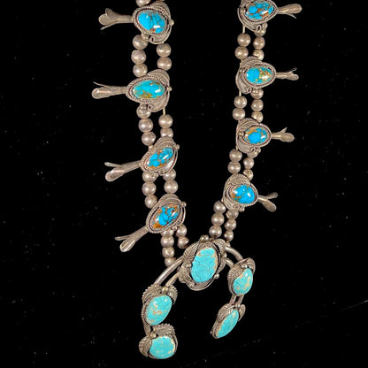 A silver Navajo men's squash blossom necklace set with Fox turquoise and Sonora turquoise.