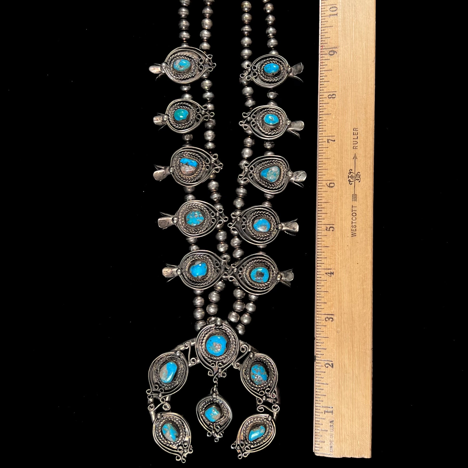 A men's Navajo silver squash blossom necklace set with Kingman turquoise stones.