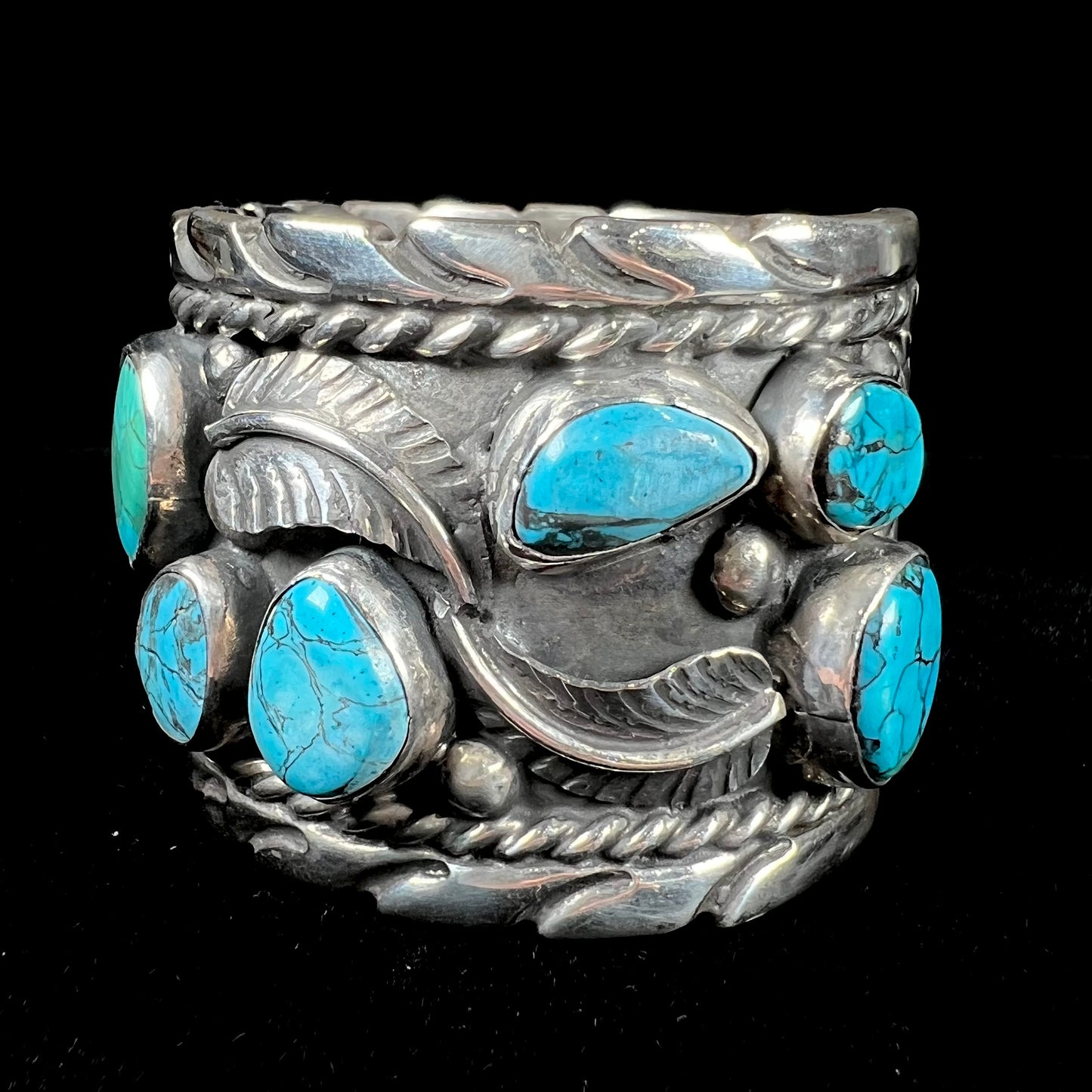 A men's sterling silver cuff bracelet bezel set with natural and synthetic turquoise stones.