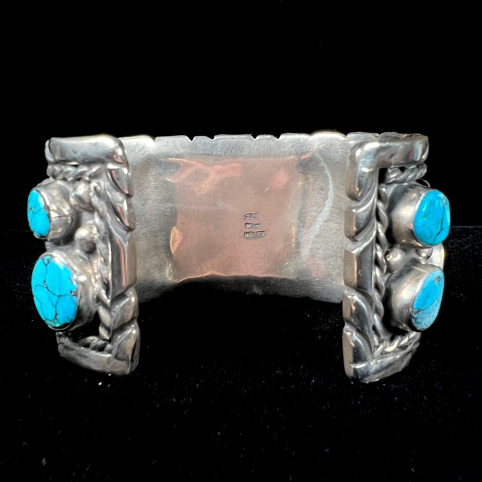 A men's sterling silver cuff bracelet bezel set with natural and synthetic turquoise stones.