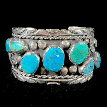 A men's sterling silver cuff bracelet bezel set with natural and synthetic turquoise stones.