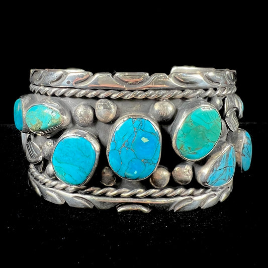 A men's sterling silver cuff bracelet bezel set with natural and synthetic turquoise stones.