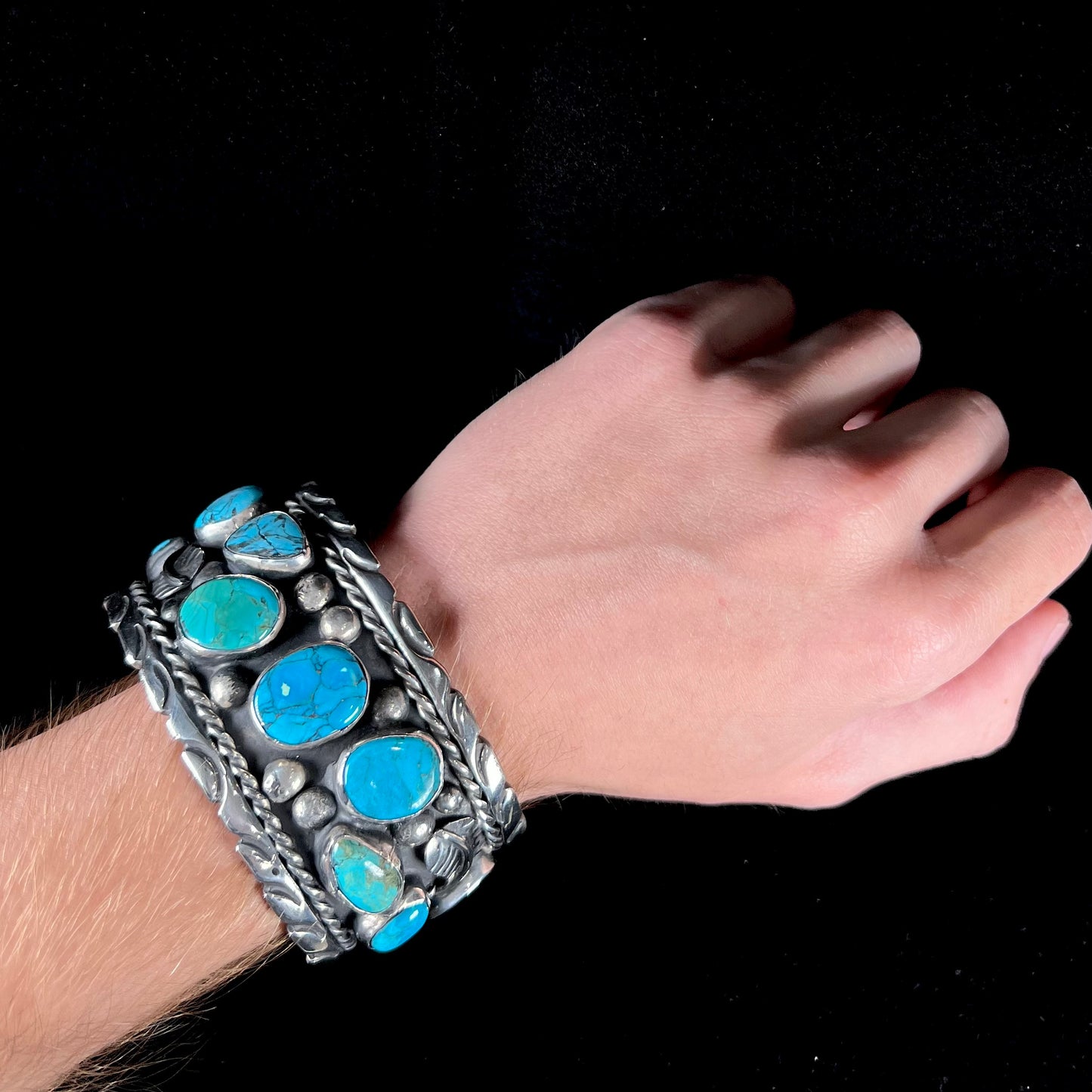 A men's sterling silver cuff bracelet bezel set with natural and synthetic turquoise stones.