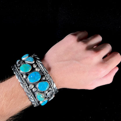 A men's sterling silver cuff bracelet bezel set with natural and synthetic turquoise stones.