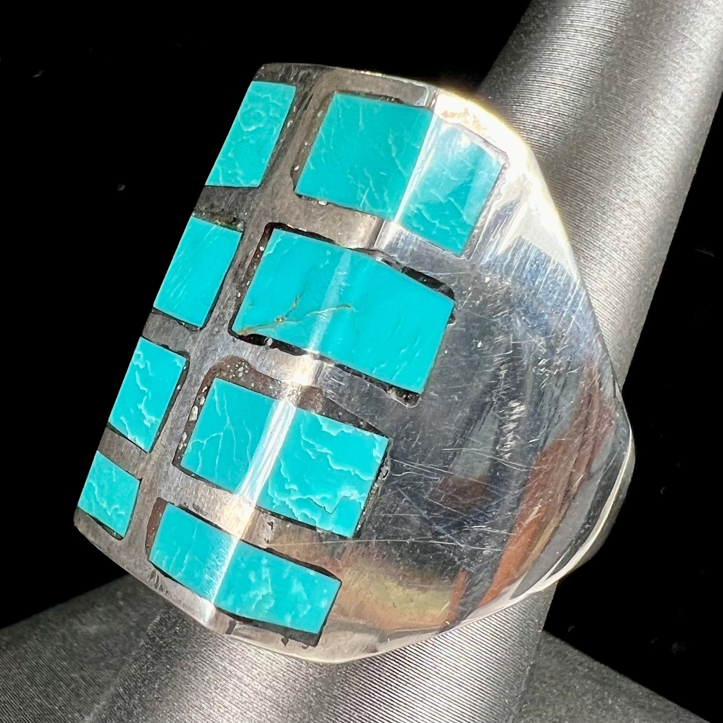 A men's sterling silver turquoise inlay ring, circa 1970.  The piece is set with 8 stones.