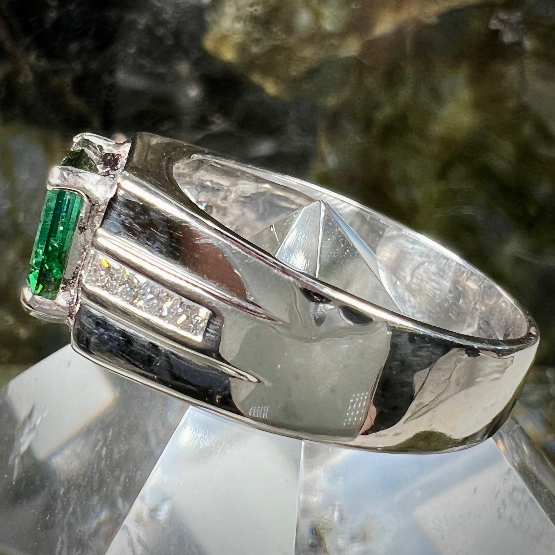 An 18k white gold green tourmaline and diamond men's ring.  The stones are princess cut.