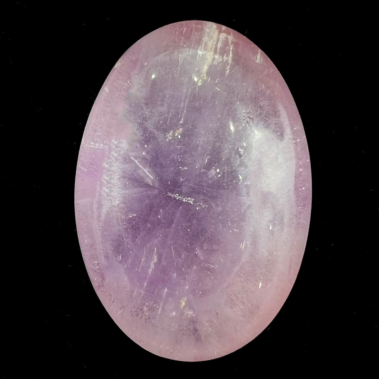 A cabochon cut red amethyst stone from Mexico.  The piece shows a faint star.