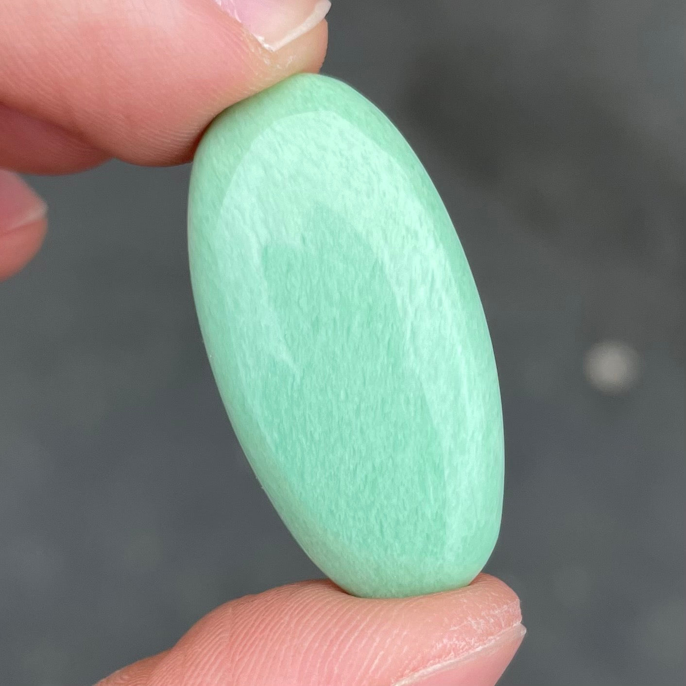 A loose, oval cabochon cut variscite stone from Utah, USA.